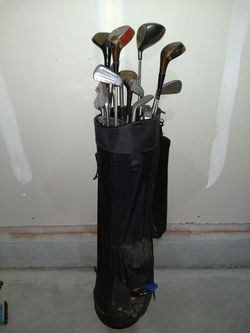 Assorted golf clubs, balls, and tees in Dunlop golf bag