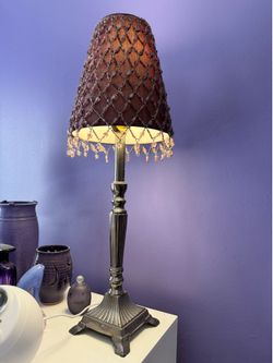 Ornate table lamp with beaded shade.