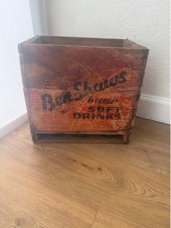 Antique vintage soda siphon (seltzer bottle) collection stored in a wooden crate.
