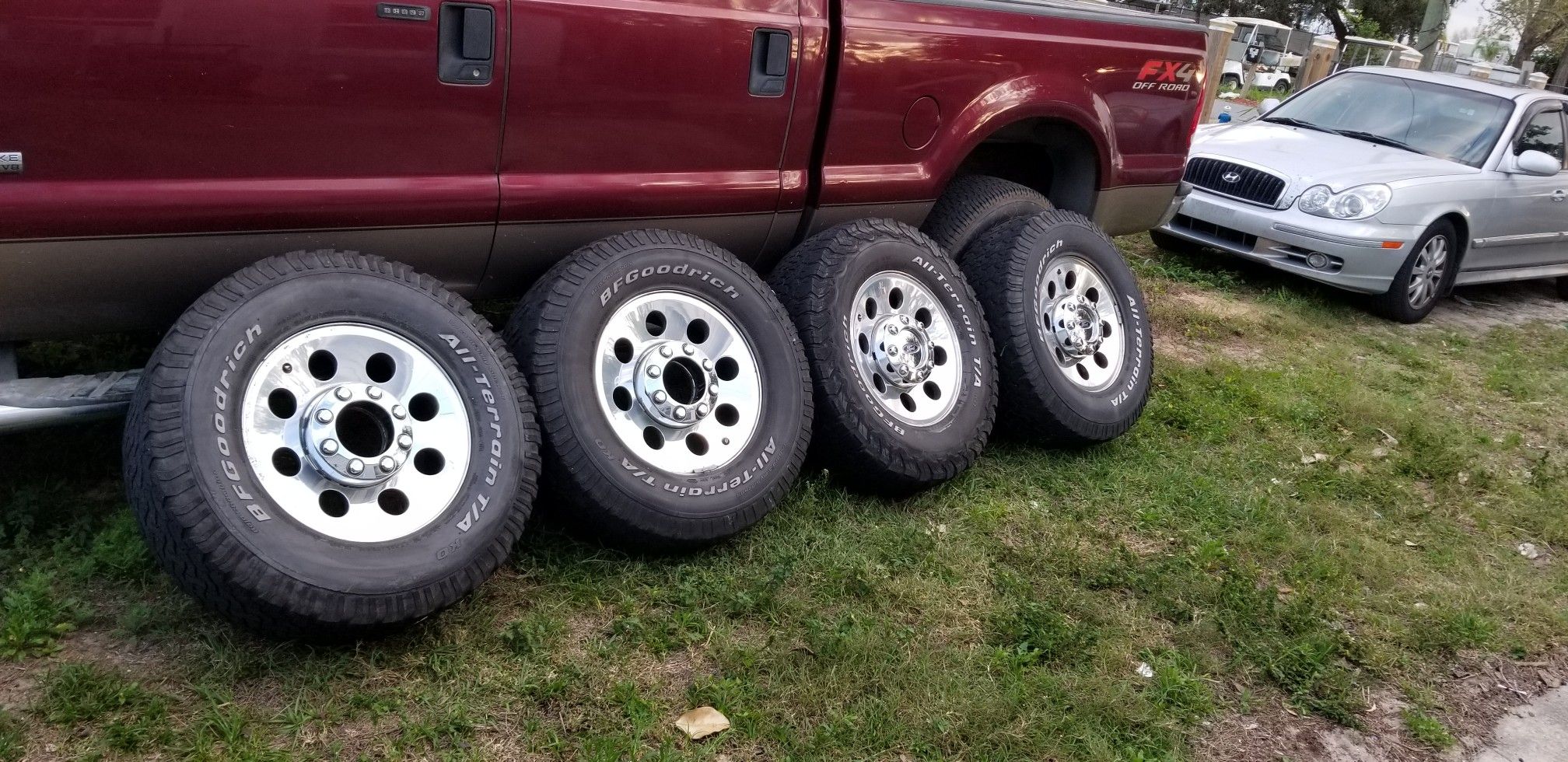 Polished aluminum wheels and tires with center caps and lug nuts off of a 2006 f250 4x4