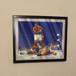 Art piece of Muhammad Ali knocking out sonny Liston in black frame