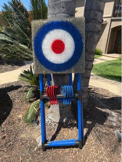 Complete EastPoint Sports axe throwing game. It has a bristle target with red, white, and blue rings. Game includes a blue stand and red and blue plas