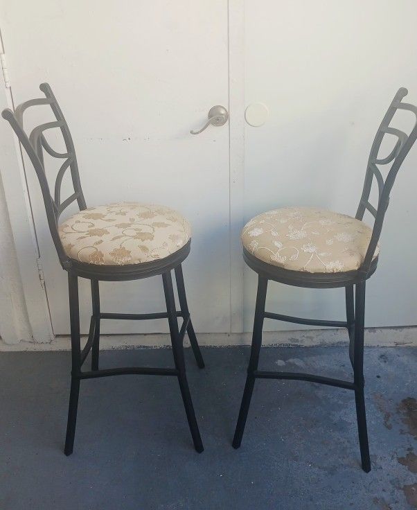 2 beige swivel bar stools