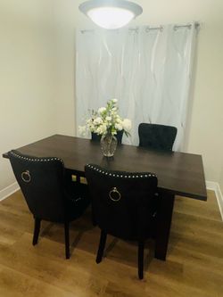 Beautiful dark wood dining table paired with black velvet chairs.