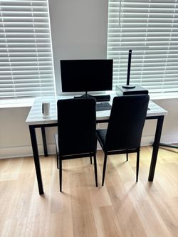 White marble table with 4 black chairs