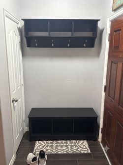 black entryway hall tree with a bench and shoe storage.