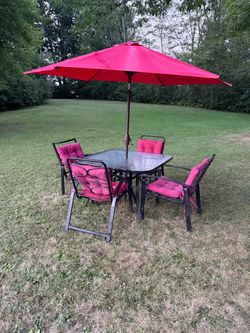 OUTDOOR PATIO FURNITURE GLASS/METAL TABLE L 44" X W 44" X HT 28", 4 METAL CHAIRS, CUSHIONS, UMBRELLA