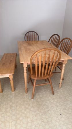 Mesa con cuatro sillas y una banca