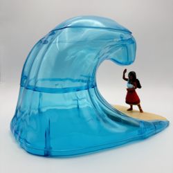 This is a Disney Moana 2 Wave Ocean Popcorn Bucket, a 2024 Regal Cinemas exclusive collectible.  It features a translucent blue wave arching over a fi