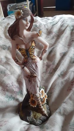 Girl statue with butterflies on her land sunflower on the bottom