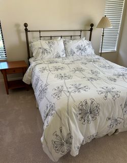 Bed, bedding, side table and floor lamp