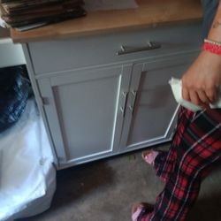 Kitchen Island With A Rolling On The Side And Cutting Board