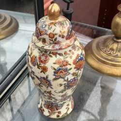 Hand-painted porcelain ginger jar with a floral and scroll pattern and gold accents.  