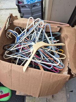 A box of plastic hangers n the wooden pant hangers