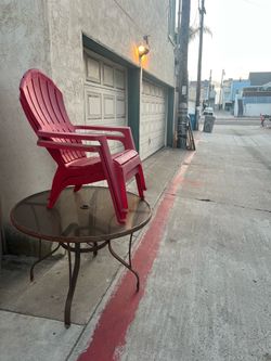Glass table, red plastic chairs, wood shelves