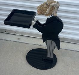Novelty butler statue side table featuring a caricature-style head with white hair, dressed in a black tuxedo with pinstripe trousers, holding a flat 