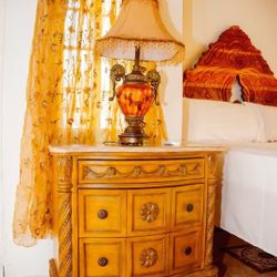 Vintage Mid-Century Hollywood Regency style table lamp with an amber glass body and ornate brass details