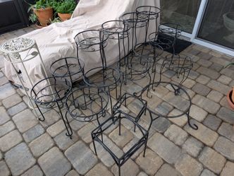 Wooden collection of various plant stands and accent tables. This set includes several pedestal-style stands with round tops, a three-legged tripod ta