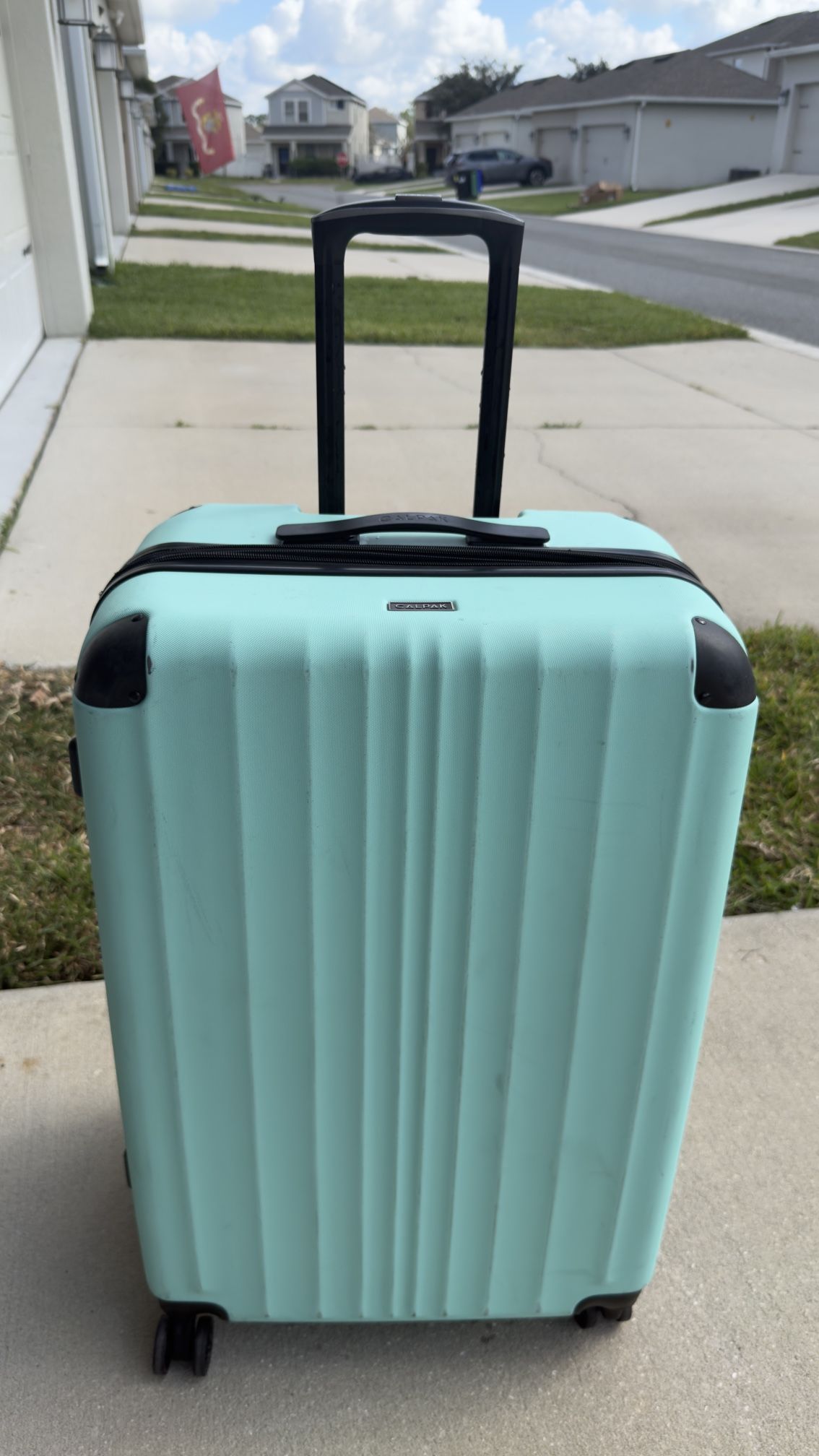 Selling a large blue Calpak suitcase.