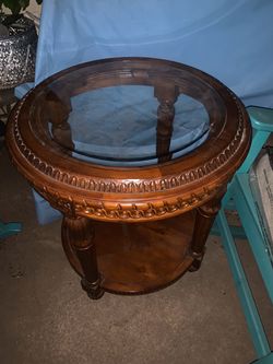 Table round wood and Beveled glass-top end or side table a dark wood finish, fluted or carved legs, an egg-and-dart or carved apron, and a lower circ