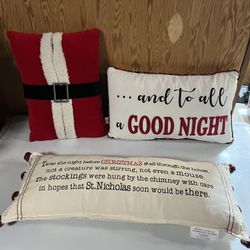 Set of three Christmas-themed decorative throw pillows festive designs and quotes. 