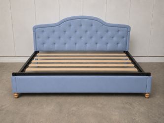 Elegant light blue velvet queen bed with a tufted headboard and timeless style.