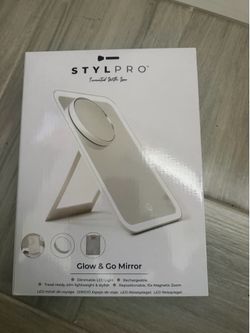 Portable LED makeup mirror with a 10x magnetic magnification attachment. This white travel mirror has dimmable LED lights and a built-in rechargeable 