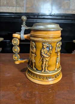 Vintage Gerz amber ceramic beer stein featuring embossed historical musician figures and a pewter lid