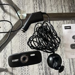 Coby dash cam with car mount and charging cords. 