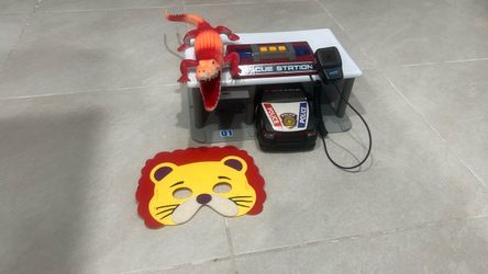 Cop car toy, lion mask, toy police station, and a crocodile