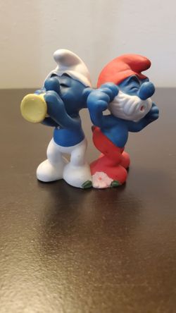 Papa Smurf and Harmony Smurf.Vintage porcelain figurine featuring Papa Smurf and Harmony Smurf.
Manufactured in 1982 by Wallace Berrie & Co., Inc. und