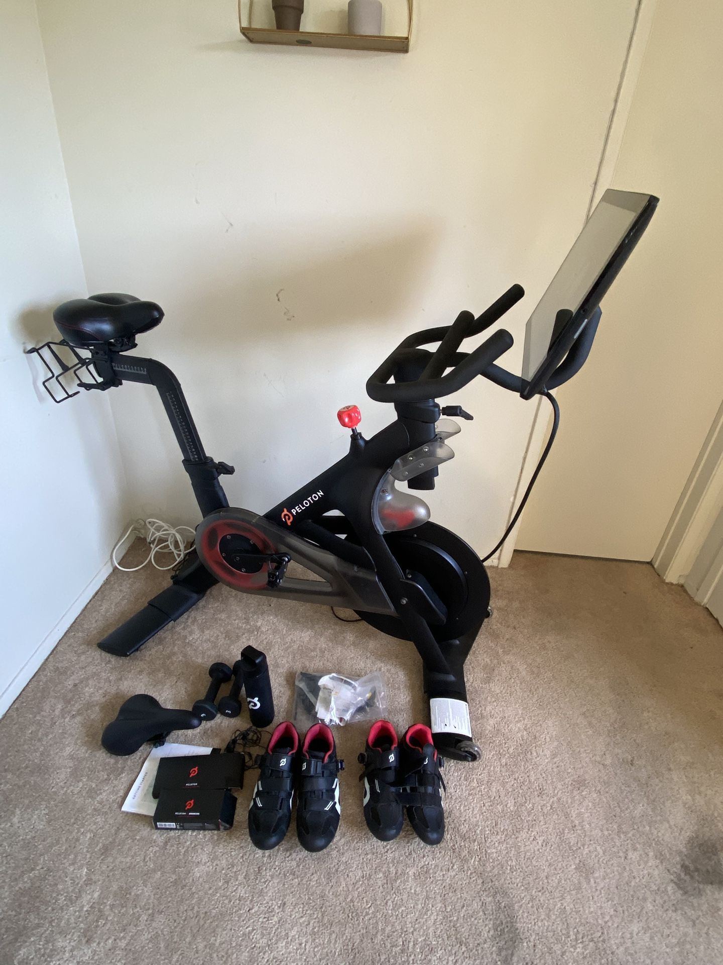 Peloton Bike + 2x Shoes, Weights, Bottle, Heart Rate Monitor, Earphones, Extra Saddle + Fixings
