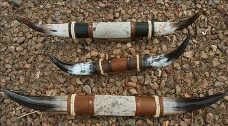 These items appear to be mounted, polished steer or cow horns with leather and cowhide center wraps, commonly used as rustic Southwestern or Western w
