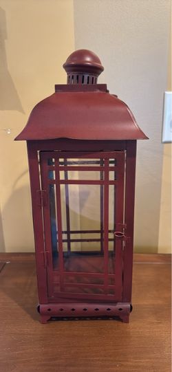 Red metal and glass Mission-style decorative candle lantern features a geometric paneled door
