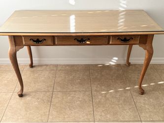 Wood desk or accent table with glass top; 3 drawers for storage; accent legs