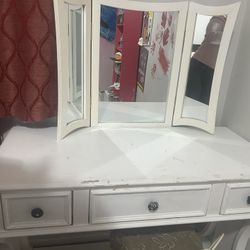 white wooden vanity desk with a three-panel mirror and three drawers
