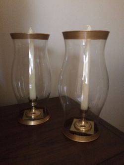 Brass candle sticks in gold rimmed glass dome