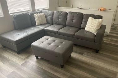 Gray leather sectional couch and ottoman