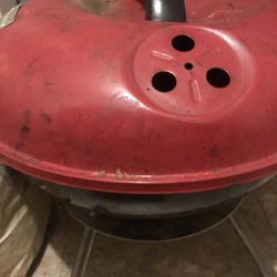 Used red charcoal grill with vented lid