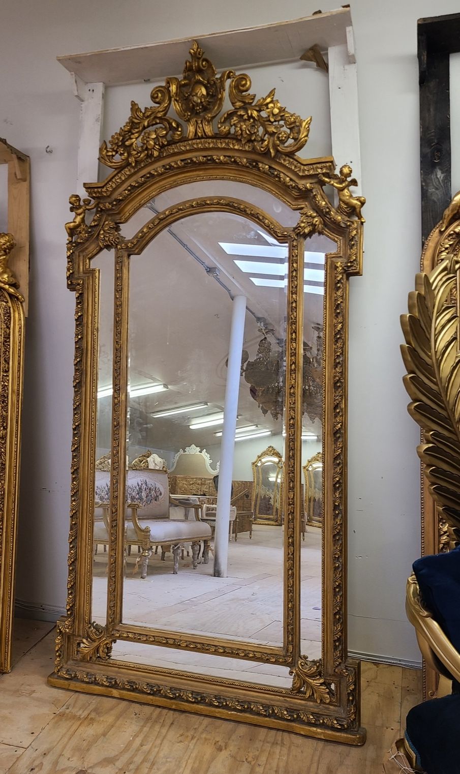 Baroque Gilded Mirror LOOK UP Ornate Baroque-style full-length gilded mirror with cherub figures. TIME PERIOD 18th Century Style ORIGIN Italy ESTIMATE