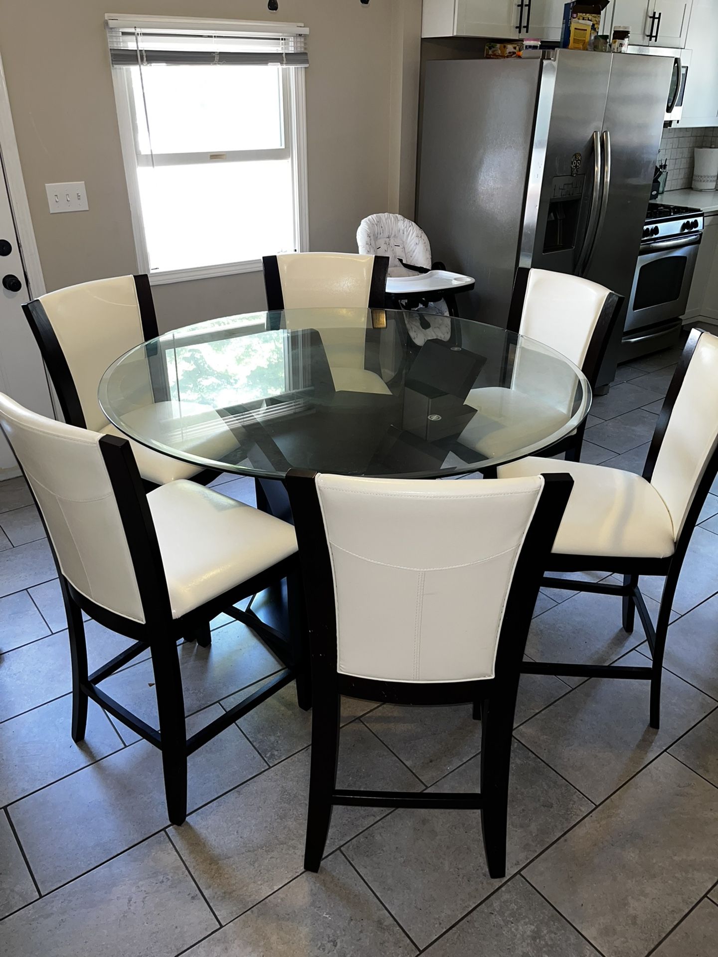 Gorgeous 48” glass counter height table and 4 chairs and lazy Susan. Additional Two chairs Available for $190. Barely used the dining set, due to hav