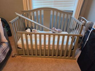 Gray crib with mattress