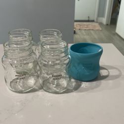 4 - 5 Ounce Advent Glads Baby Bottles And A Sleeve.