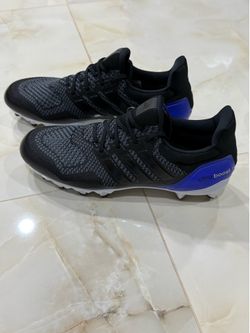 Adidas Ultraboost football cleats in black with a blue heel counter.