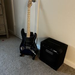 Blue guitar, with holder and fender amp