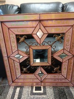 A diamond mirror with glass all around with gold trimming inside purple