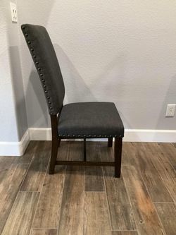Six gray upholstered chairs with walnut legs and nailhead trim. (20.5W × 20D x 42H) Chairs are in great condition- like new. Condition Used - like new
