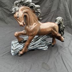 Horse, jumping over a log statue