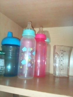 Baby bottles and sippy cup with a pacifier
