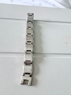 Vintage-style stainless steel watch band with articulated links and a folding clasp. Classic and elegant design.